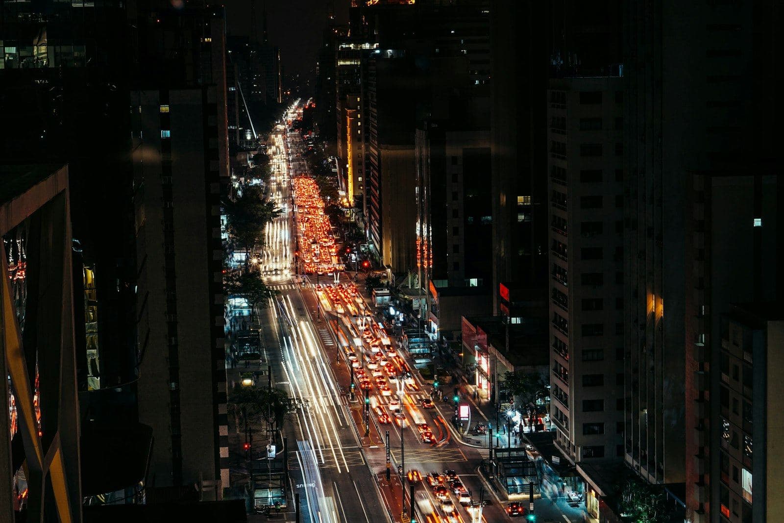 Semáforo vermelho em cruzamento de avenida à noite